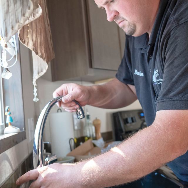 Technician installing a kitchen faucet