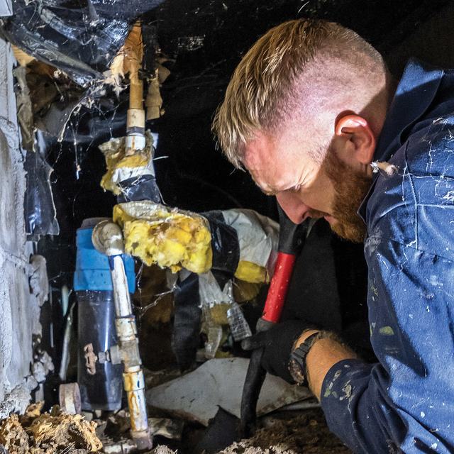 Technicians repairing piping beneath a Shore home
